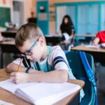 Young students engaged in writing activities during a classroom session.