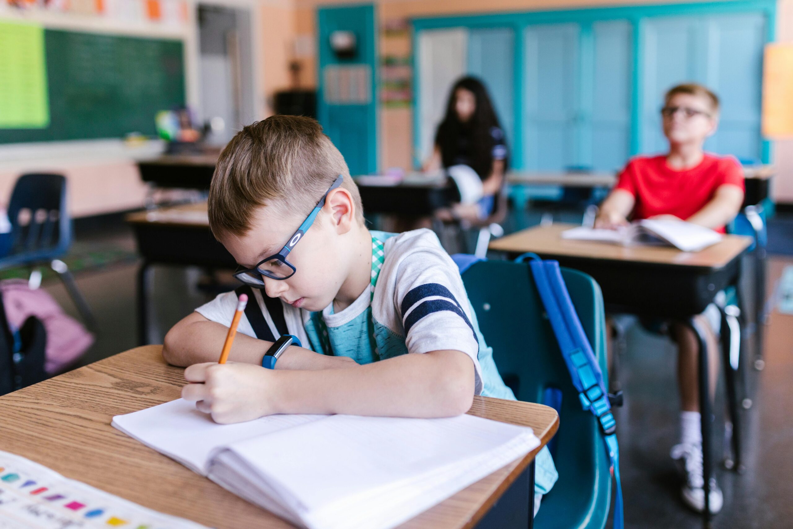 Young students engaged in writing activities during a classroom session.